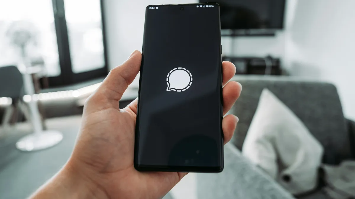 Mão segurando um celular que recebe a notificação do alarme monitorado pelo aplicativo