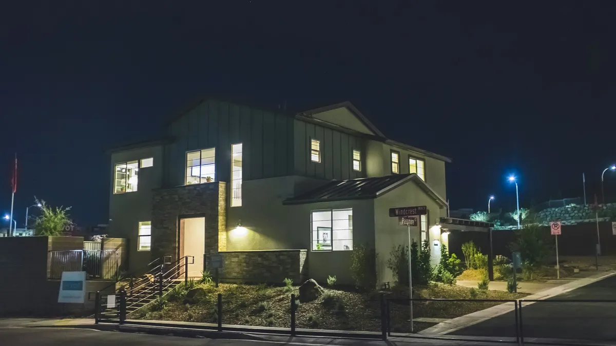 Casa iluminada à noite, protegida por alarme monitorado com aviso à empresa de segurança