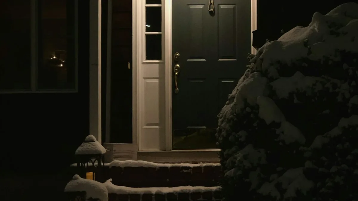 Porta de uma casa à noite com luz acesa na entrada, ponto onde um sensor de presença externo ajuda