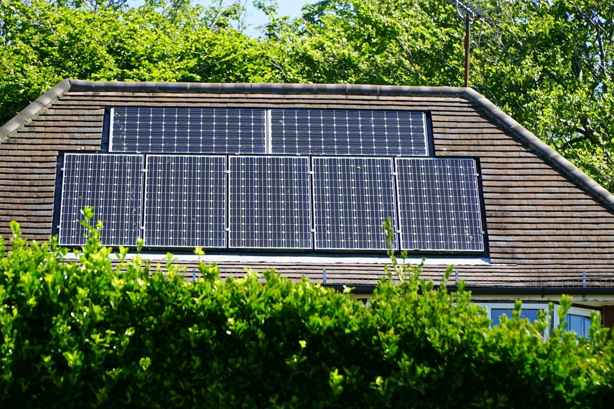 Telhado de casa com placa solar instalada, cenário típico de uma câmera com placa solar