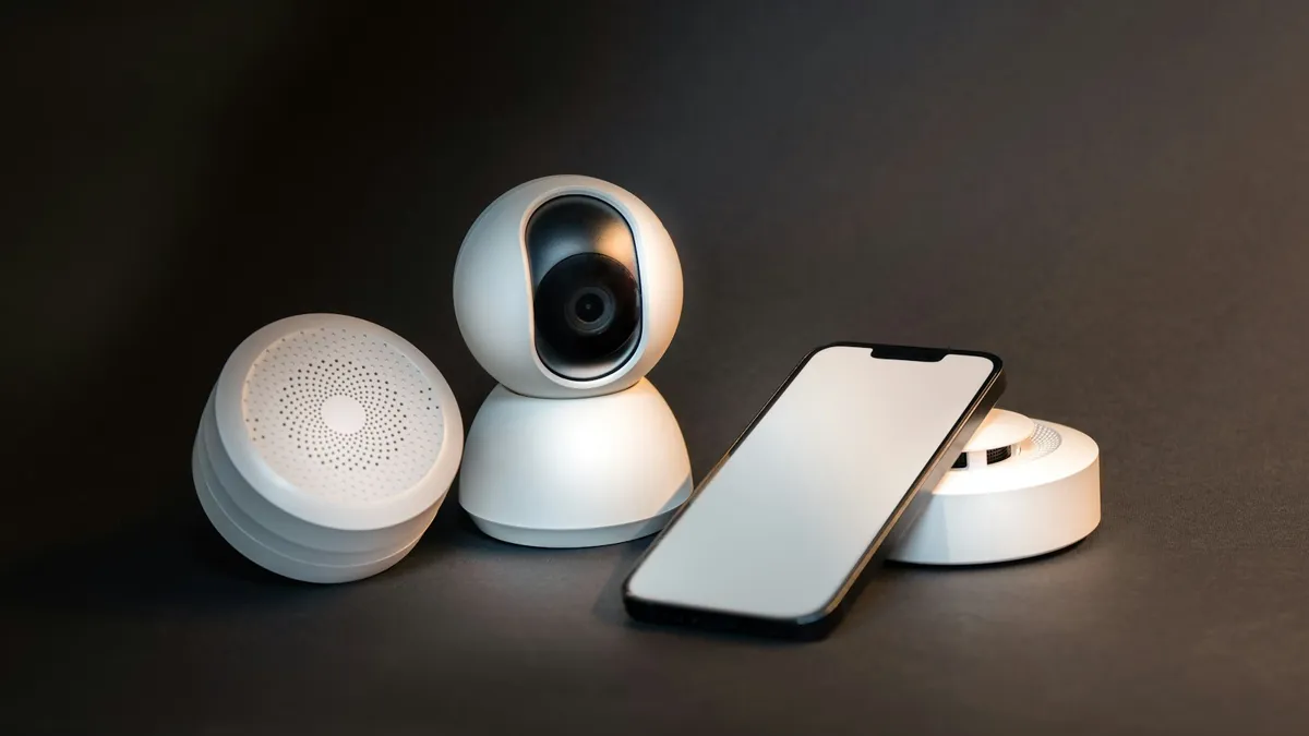 Smartphone ao lado de uma câmera de segurança