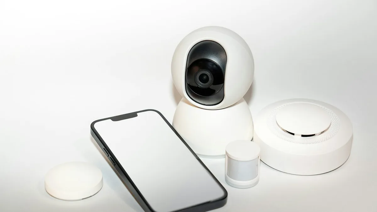 Smartphone ao lado de câmera de segurança, usado para ver imagens remotas