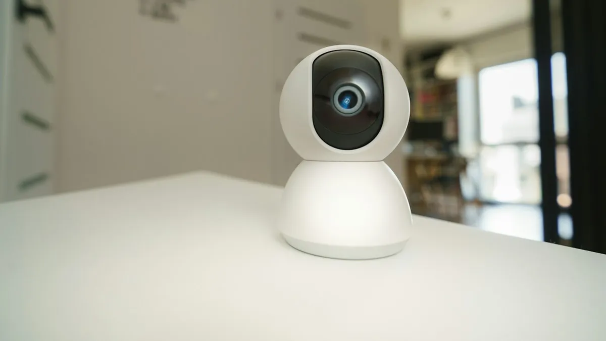 Câmera de segurança wifi branca sobre uma mesa clara em ambiente interno