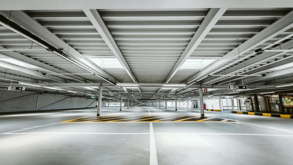 Estacionamento coberto amplo com teto de concreto e iluminação
