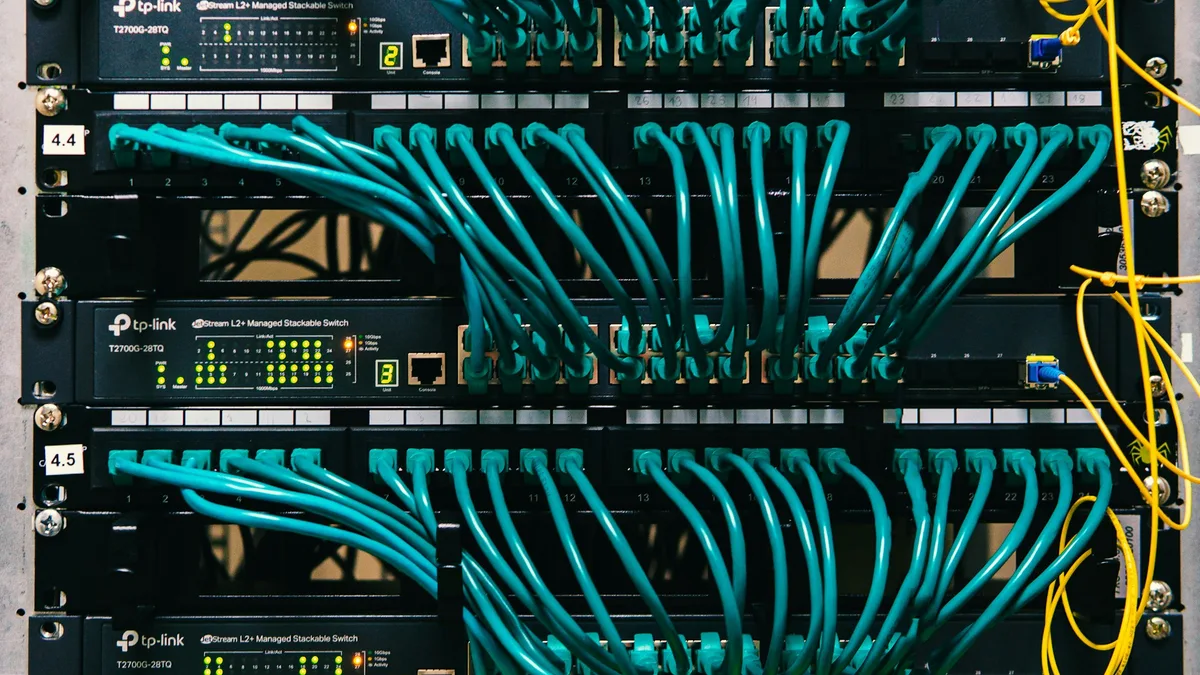 Patch panel com cabos de rede organizados em um rack, base de uma instalação PoE