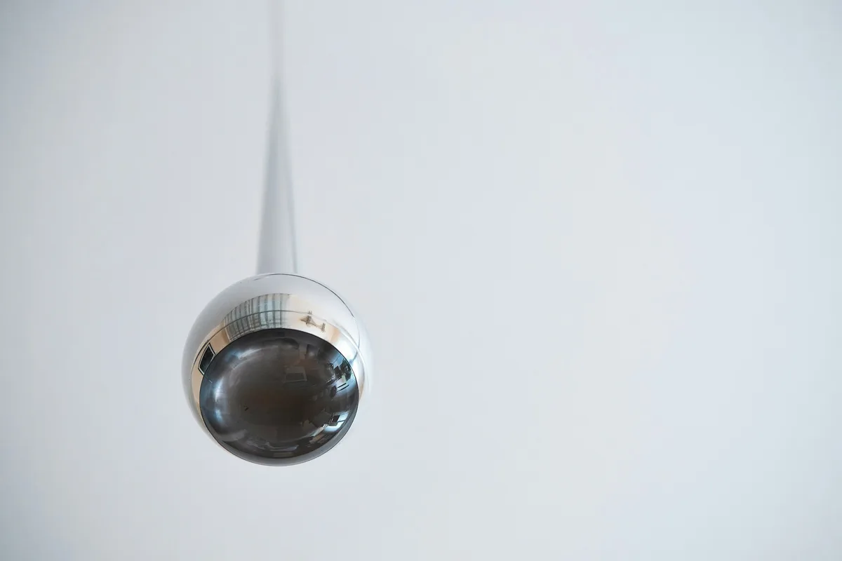 Câmera dome branca pendurada no teto, cenário típico de uma câmera dome ip