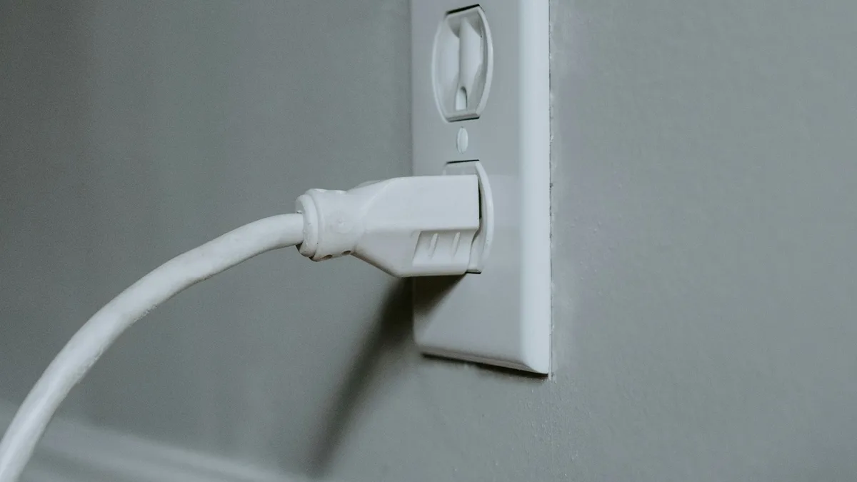 Tomada de parede com um carregador USB ligado, um dos objetos onde uma câmera espiã pode estar escondida