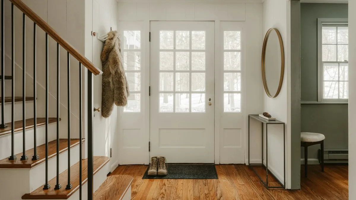Hall de entrada com porta preta e piso de madeira clara, ponto comum para instalar uma câmera Jortan