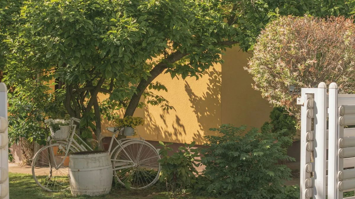 Jardim com bicicleta antiga, árvore e muro amarelo, imagem de área externa residencial