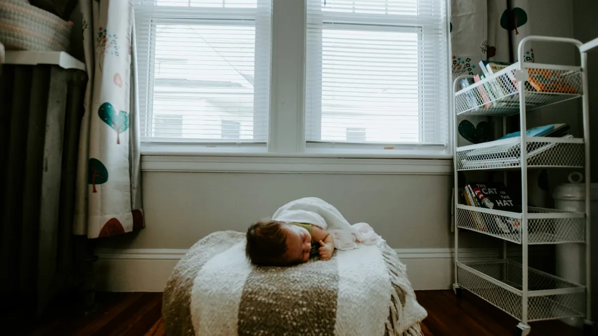 Quarto de bebê com berço de madeira e janela, ambiente em que uma câmera Xiaomi interna costuma ser usada