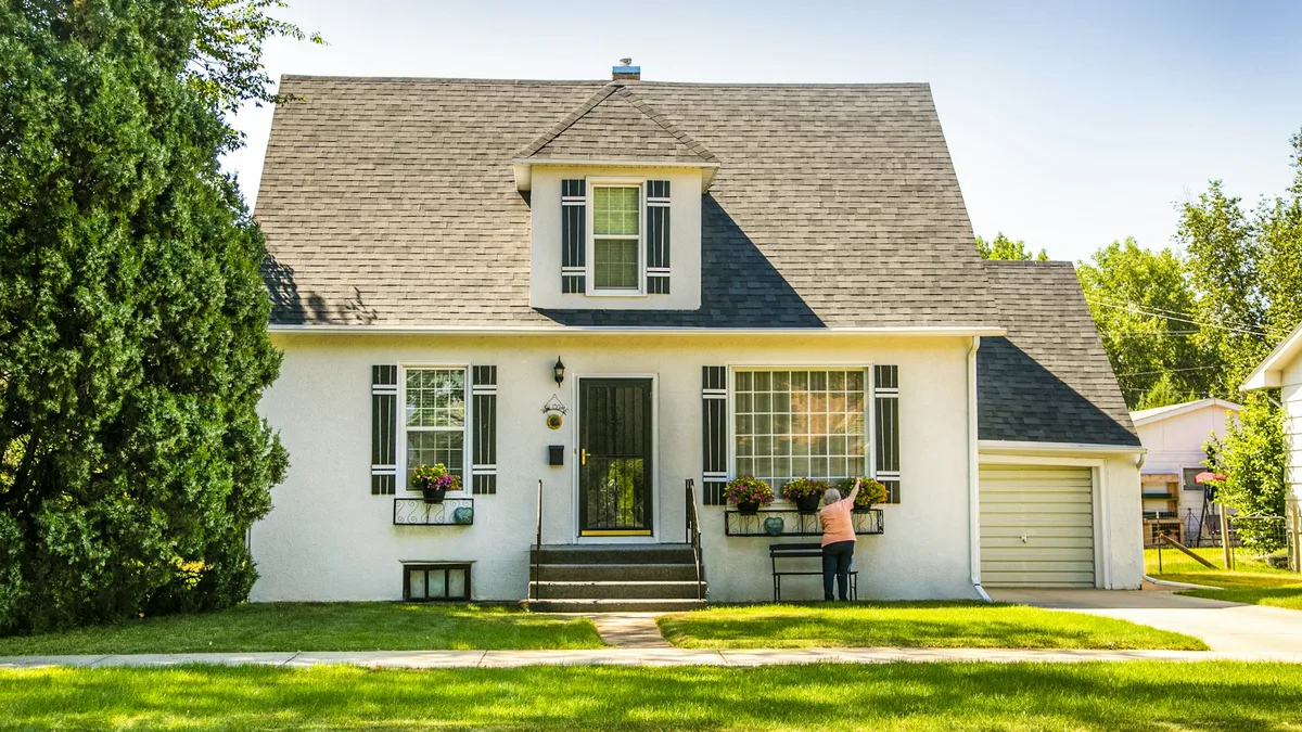 Casa branca com garagem e jardim, exemplo de fachada para câmera de segurança