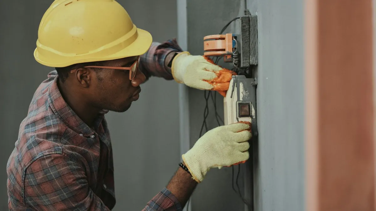 Pessoa de capacete instalando equipamento em caixa de medição presa à parede