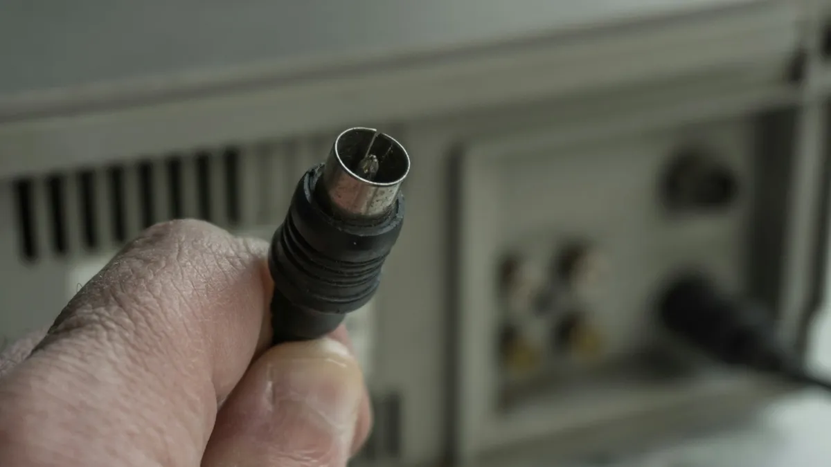 Mão segurando conector de cabo