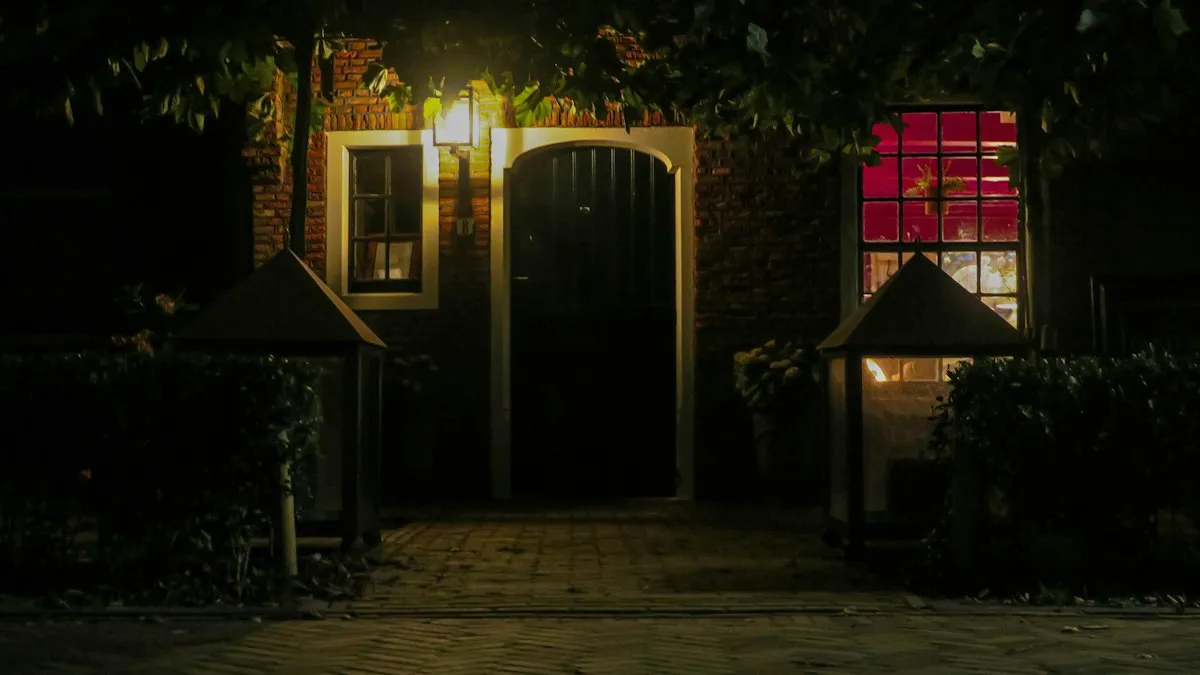 Entrada de casa à noite com iluminação de jardim, cena típica de monitoramento com câmera externa