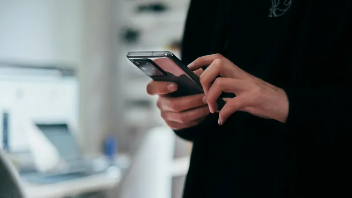 Mão segurando um celular, representando o app de controle de uma câmera Wi-Fi