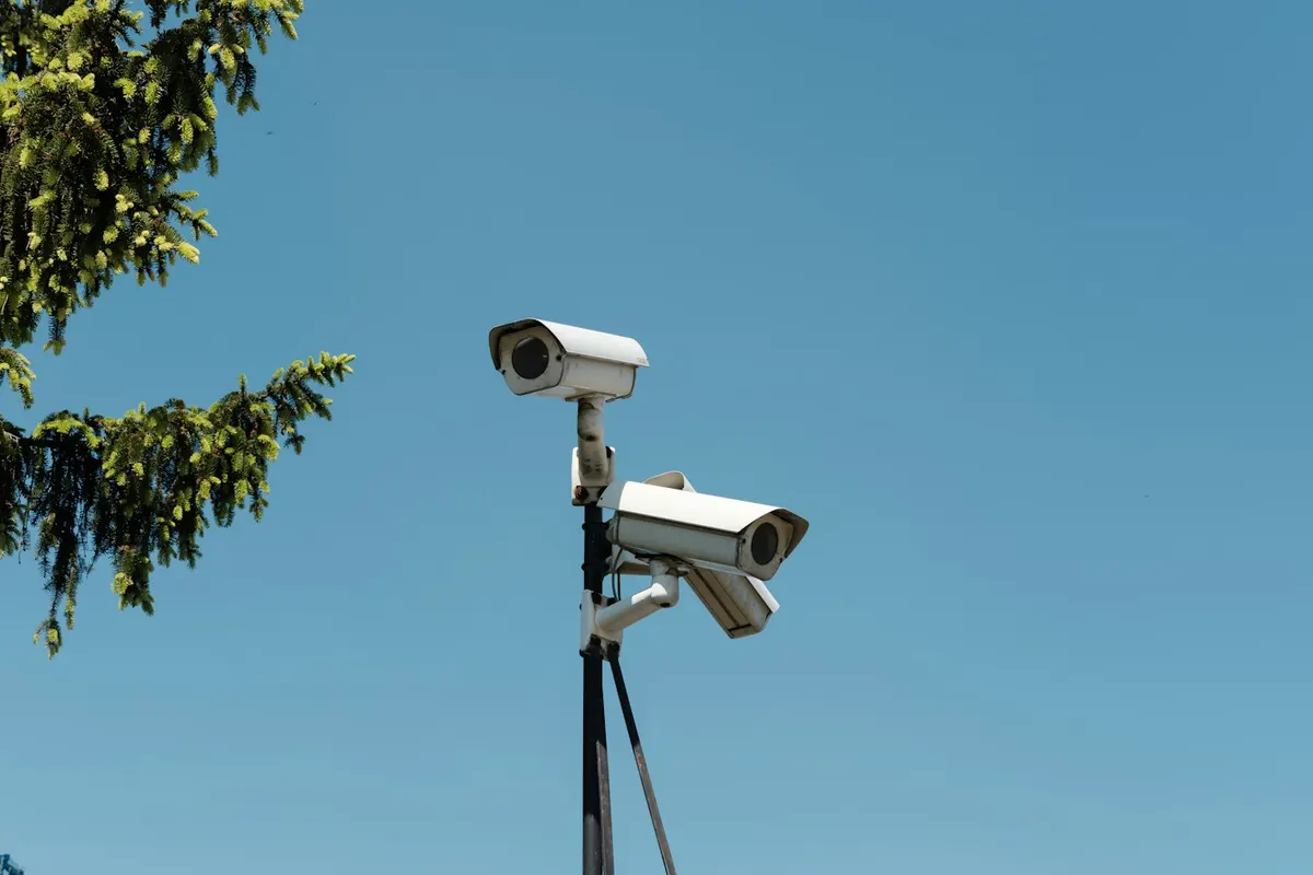 Duas câmeras IP brancas instaladas em poste externo