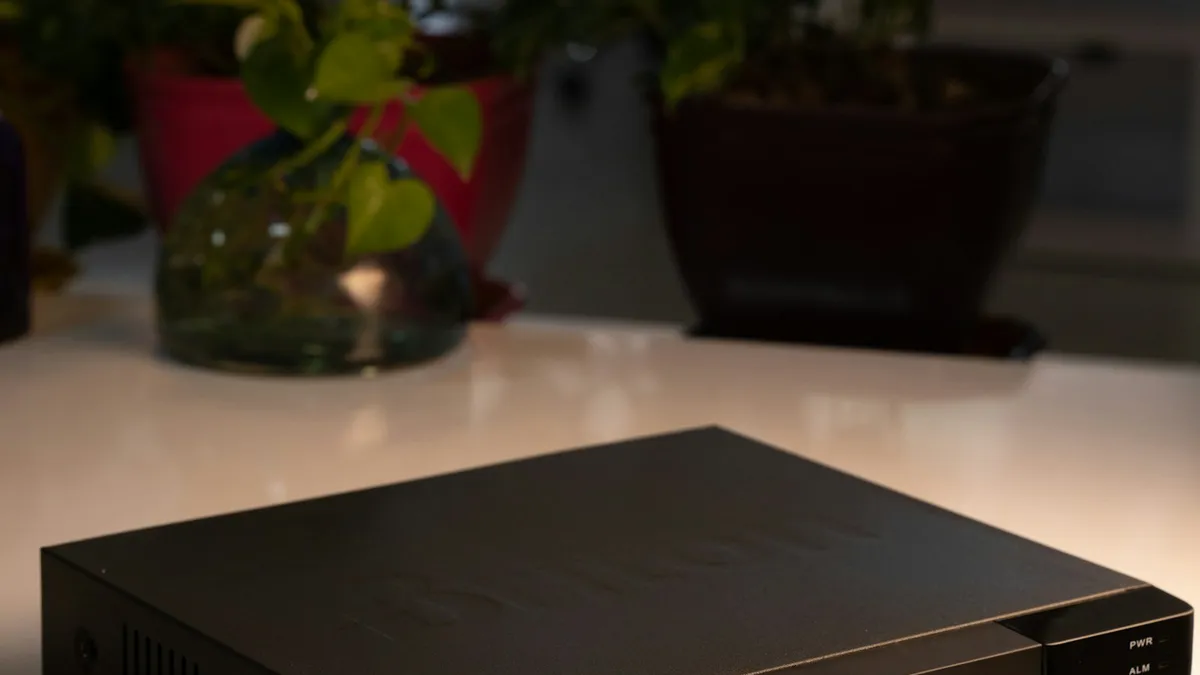 Aparelho gravador preto sobre uma mesa branca