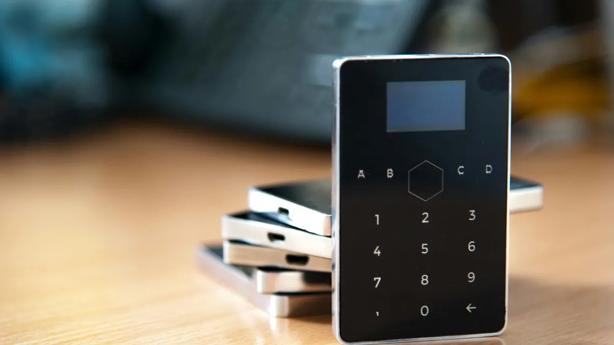 Teclado de alarme preto sobre uma mesa de madeira, exemplo de central de alarme para casa