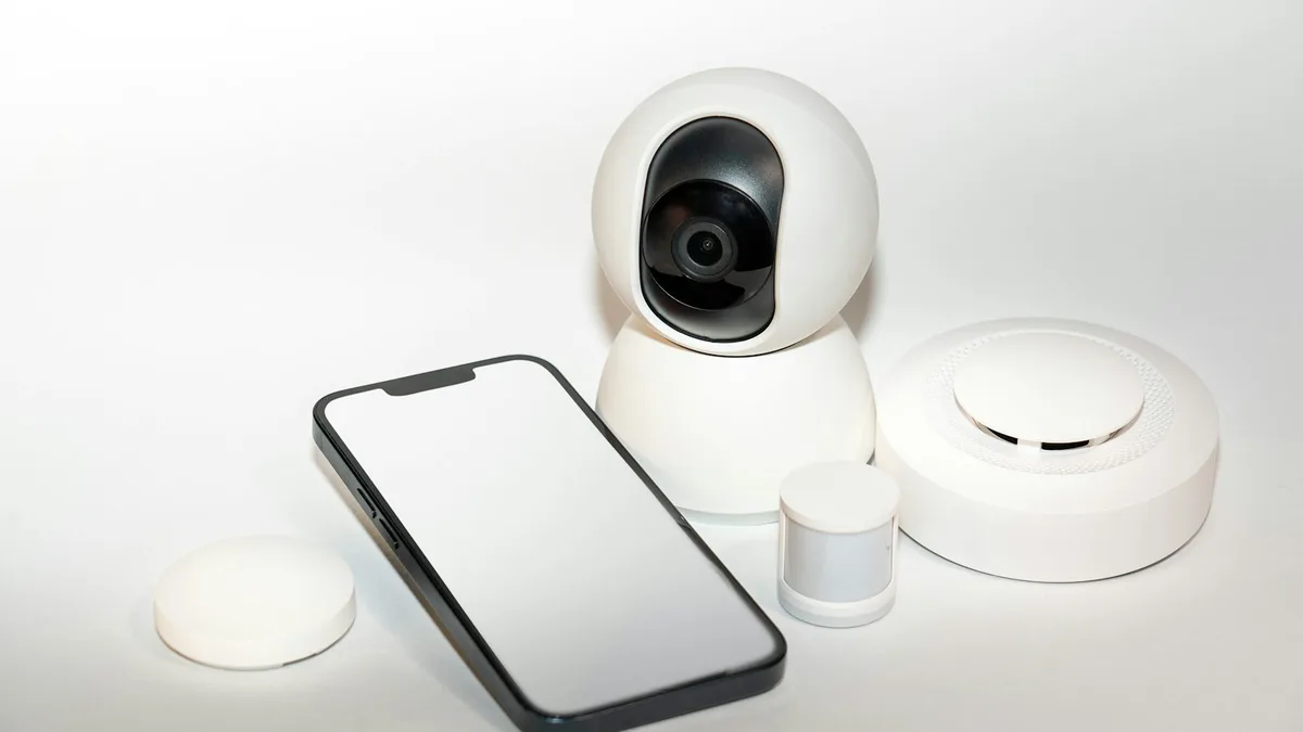 Smartphone ao lado de câmera de segurança Wi-Fi mostrando o aplicativo