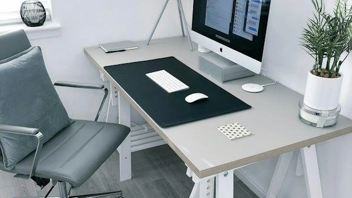Mesa de escritório em casa com monitor, cadeira e planta, ambiente onde o Wi-Fi e a câmera precisam funcionar